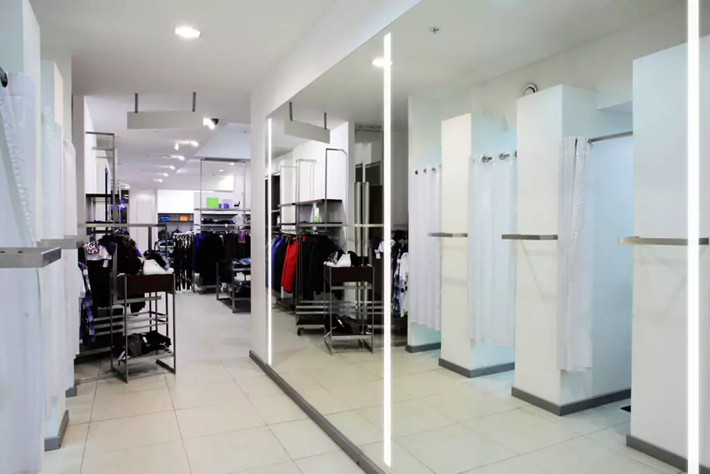 A lengthy, lighted mirror was installed in the fitting room of a clothing store.