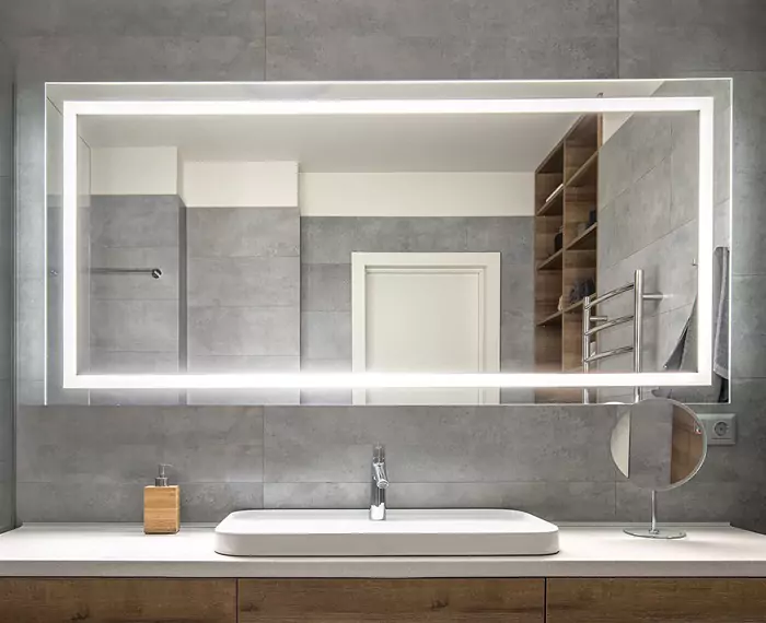 Vanity basin with a bespoke mirror installed in a ceramic matt tiles wall.